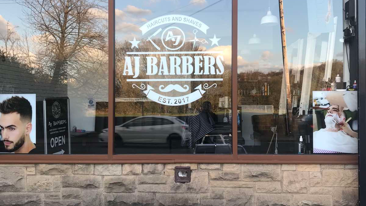 AJ Barbers window on Low Lane, with its white lettering and established 2017 sign